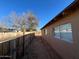 Side yard with dirt ground, wooden fence, and a tree at 3542 E Earll Dr, Phoenix, AZ 85018