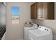 Laundry room with washer, dryer, and upper cabinets at 9243 E Sector Dr, Mesa, AZ 85212