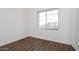 Simple bedroom with large window and dark wood-look floors at 3823 W Lodge Dr, Laveen, AZ 85339