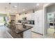 Modern kitchen with white cabinets, granite countertops, and stainless steel appliances at 1952 N 212Th Ln, Buckeye, AZ 85396