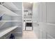 Bright laundry room with washer, dryer, and ample shelving at 1952 N 212Th Ln, Buckeye, AZ 85396