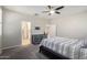 Comfortable bedroom with carpeted floor, ceiling fan, and ensuite bathroom at 1952 N 212Th Ln, Buckeye, AZ 85396