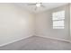 Simple bedroom with large window and ceiling fan at 1952 N 212Th Ln, Buckeye, AZ 85396