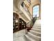 Grand curved staircase with ornate railing and built-in shelving at 20567 N 112Th St, Scottsdale, AZ 85255