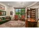Home library with large windows, comfortable seating, and extensive built-in bookshelves at 9719 E Madera Dr, Scottsdale, AZ 85262