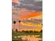Stunning sunset over a peaceful lake and golf course at 23817 S Harmony Way, Sun Lakes, AZ 85248