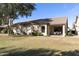 Home's backyard with covered patio, grassy area, and mature trees at 23817 S Harmony Way, Sun Lakes, AZ 85248