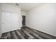 Simple bedroom with double door closet and grey wood-look flooring at 12568 W Orangewood Ave, Glendale, AZ 85307