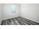 Cozy bedroom with grey wood-look flooring and large window at 12568 W Orangewood Ave, Glendale, AZ 85307