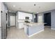 Modern kitchen featuring white cabinets, granite island, and stainless steel appliances at 12568 W Orangewood Ave, Glendale, AZ 85307