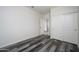 Well-lit bedroom featuring double door closet and grey wood-look flooring at 12568 W Orangewood Ave, Glendale, AZ 85307