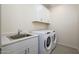 Laundry room with washer, dryer, and cabinets at 12568 W Orangewood Ave, Glendale, AZ 85307