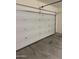 Interior view of a clean, attached garage with a white automatic door at 20216 W Desert Bloom St, Buckeye, AZ 85326