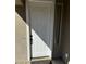 White front door with black hardware, next to a sidelight window at 20216 W Desert Bloom St, Buckeye, AZ 85326