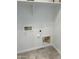 A well-lit laundry area with hookups, electrical outlets, and a water shut-off valve at 20216 W Desert Bloom St, Buckeye, AZ 85326