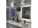 Modern bathroom with double sinks, a large lit mirror, and white cabinets at 20216 W Desert Bloom St, Buckeye, AZ 85326