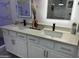 Modern bathroom with double sinks and white cabinets at 20216 W Desert Bloom St, Buckeye, AZ 85326