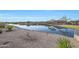 Peaceful lake view with walking path and lush landscaping at 16866 S 180Th Ave, Goodyear, AZ 85338