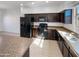 Modern kitchen with dark cabinets and granite counters at 1842 N 77Th Gln, Phoenix, AZ 85035