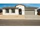 Single-story home with arched entryway, neutral color palette, and paved driveway at 3636 W Summerside Rd, Laveen, AZ 85339