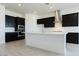 Modern kitchen with dark cabinetry, white quartz countertops, and herringbone backsplash at 3636 W Summerside Rd, Laveen, AZ 85339