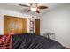 Bright bedroom with double bed, ceiling fan, and wood closet doors at 748 S Rico Cir, Mesa, AZ 85204