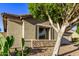 Tan house exterior with stone accents and mature trees in the front yard at 13506 W Earll Dr, Avondale, AZ 85392