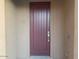 A maroon front door welcomes guests to this beautiful home at 15685 W Mackenzie Dr, Goodyear, AZ 85395
