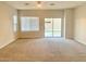 Bright living room with sliding glass doors to backyard at 15685 W Mackenzie Dr, Goodyear, AZ 85395