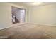 Spacious living room with neutral carpeting and staircase at 15685 W Mackenzie Dr, Goodyear, AZ 85395