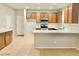 Spacious kitchen with wood cabinets, an island, and light countertops at 15685 W Mackenzie Dr, Goodyear, AZ 85395