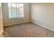 Bright bedroom with carpeted floor and large window at 15685 W Mackenzie Dr, Goodyear, AZ 85395