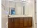 Double vanity bathroom with wood cabinets and large mirror at 15685 W Mackenzie Dr, Goodyear, AZ 85395