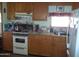 Kitchen with wood cabinets, stove, and refrigerator at 201 S Greenfield Rd # 197, Mesa, AZ 85206