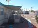 Mobile home with covered porch, desert landscaping, and a walkway at 201 S Greenfield Rd # 197, Mesa, AZ 85206