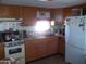 Kitchen with wood cabinets, stove, and refrigerator at 201 S Greenfield Rd # 197, Mesa, AZ 85206