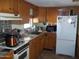 Kitchen with wood cabinets, stove, and refrigerator at 201 S Greenfield Rd # 197, Mesa, AZ 85206