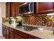 Kitchen features gas cooktop, microwave, and stylish backsplash at 41906 W Solitare Dr, Maricopa, AZ 85138