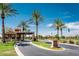Gated community entrance with palm trees and welcoming signage at 41906 W Solitare Dr, Maricopa, AZ 85138