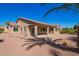 Home's exterior with covered patio and desert landscaping at 42915 W Kingfisher Dr, Maricopa, AZ 85138