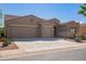 Tan two-story house with a three-car garage and desert landscaping at 42915 W Kingfisher Dr, Maricopa, AZ 85138