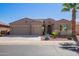 Tan two-story house with a three-car garage and desert landscaping at 42915 W Kingfisher Dr, Maricopa, AZ 85138