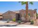Tan two-story house with a three-car garage and desert landscaping at 42915 W Kingfisher Dr, Maricopa, AZ 85138