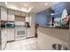 Open kitchen boasts white cabinets, granite countertops, and breakfast bar at 18202 N Cave Creek Rd # 107, Phoenix, AZ 85032