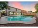 Inviting backyard oasis featuring a sparkling pool and spacious grassy area at 15163 W Cameron Dr, Surprise, AZ 85379