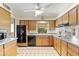 Galley kitchen with wood cabinets and black appliances at 4019 E Calypso Ave, Mesa, AZ 85206