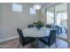 Casual dining area with a round glass table and four black chairs, next to sliding glass doors at 9515 E Rainbow Ave, Mesa, AZ 85212