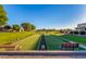 Community bocce ball court with benches and green playing area at 2101 S Meridian Rd # 172, Apache Junction, AZ 85120