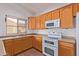 Bright kitchen with oak cabinets, white appliances, and tile flooring at 2101 S Meridian Rd # 172, Apache Junction, AZ 85120