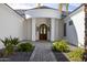 Elegant entryway with a beautiful arched wooden door and a stone pathway at 22474 S 199Th Cir, Queen Creek, AZ 85142